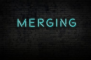 Neon işareti. Kelimeler tuğla duvara karşı birleşiyor. Gece görünümü