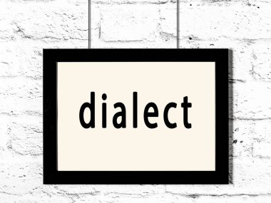 Beyaz tuğla duvarda asılı siyah çerçeve ve yazı lehçesi