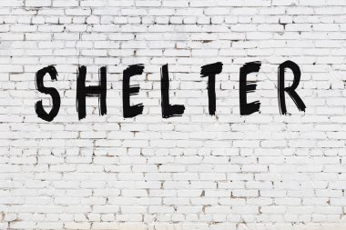 Beyaz tuğla duvara yazılmış bir sığınak.