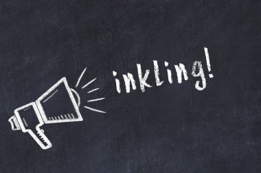 Tebeşir hoparlörü ve kara karatahtaya yazılmış yazı.