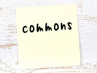 Tahta duvarda el yazısıyla yazılmış sarı yapışkan bir not.