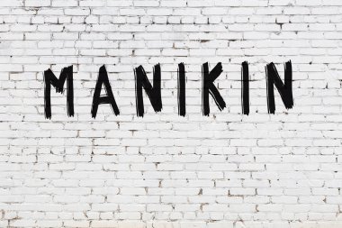 Üzerinde siyah boya yazılı manikin olan beyaz duvar.