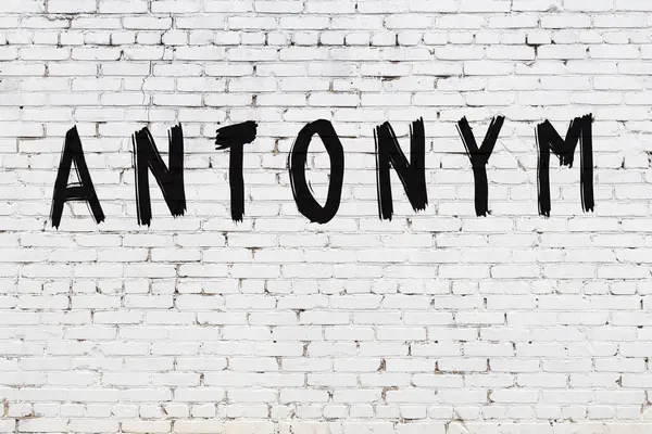 Üzerinde siyah boya yazıları olan beyaz duvar.