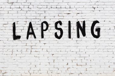 Üzerinde siyah boya yazıları olan beyaz duvar.