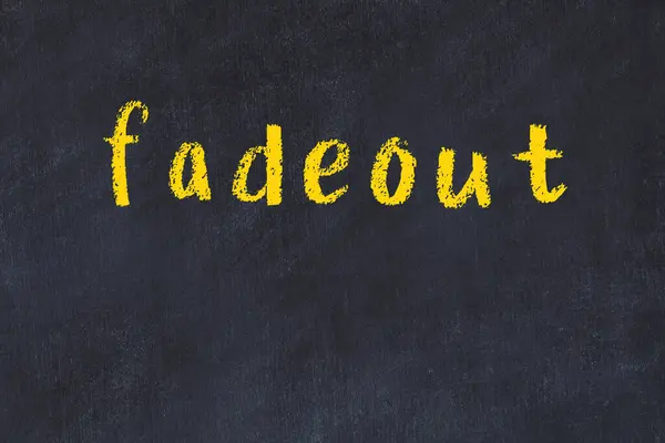 Fadeout 이라는 단어가 쓰여 있는 대학 분필로 된 책상 — 스톡 사진