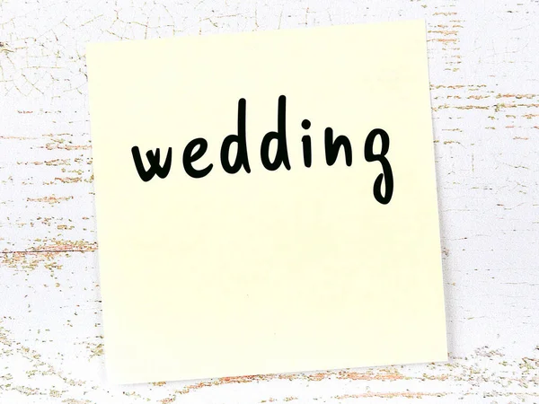 Желтый лист бумаги со словом "свадьба". Концепция напоминания — стоковое фото