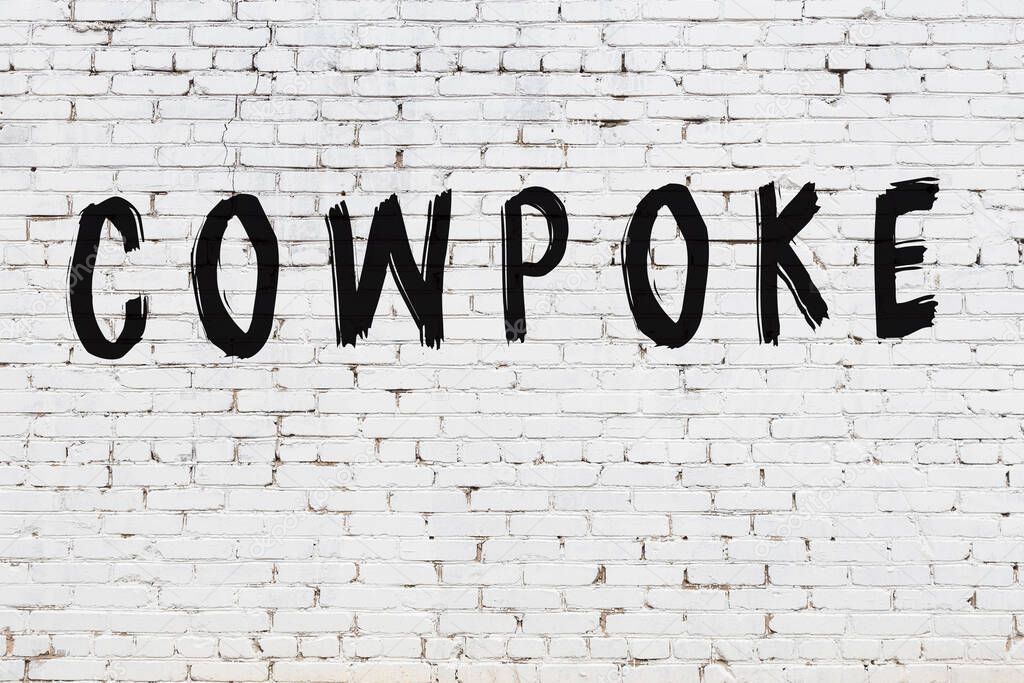 White wall with black paint inscription cowpoke on it