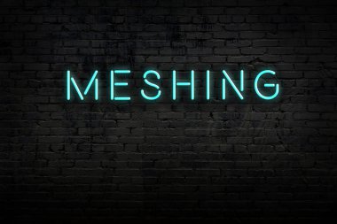 Neon işareti. Kelimeler tuğla duvara karşı birleşiyor. Gece görünümü