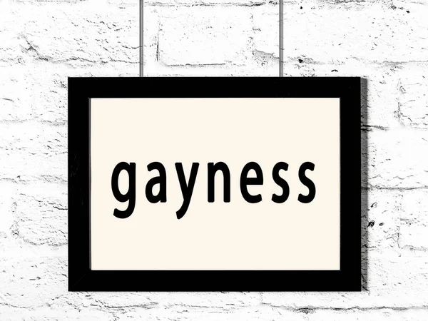 Quadro preto pendurado na parede de tijolo branco com gayness inscrição — Fotografia de Stock
