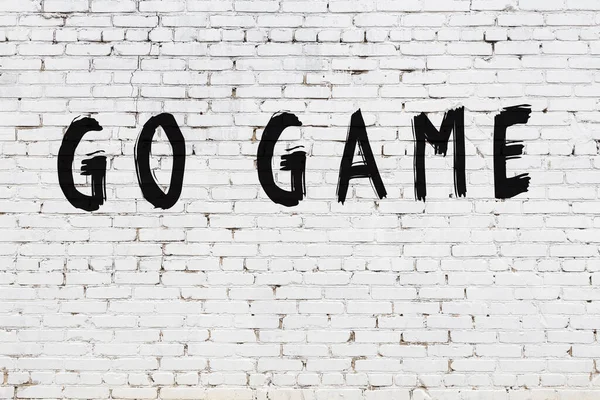 Inschrift Go-Spiel auf weißem Ziegelstein gemalt — Stockfoto