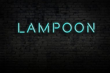 Neon işareti. Kelime Lampoon tuğla duvara karşı. Gece görünümü