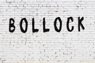 Beyaz tuğla duvara kazınmış bir yazı.