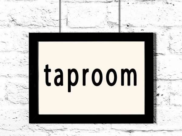 Svart ram hängande på vit tegelvägg med inskription taproom — Stockfoto