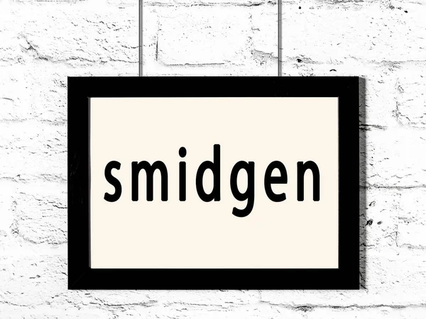 Quadro preto pendurado na parede de tijolo branco com inscrição smidgen — Fotografia de Stock