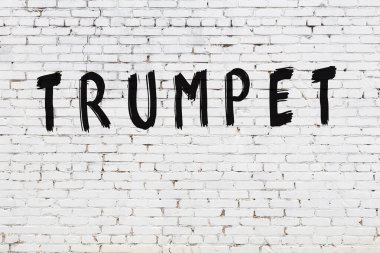 Üzerinde siyah boyalı trompet olan beyaz duvar.