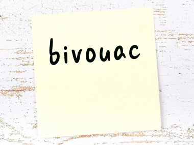 Tahta duvardaki sarı yapışkan notta el yazısıyla yazılmış ordugâh yazısı var.