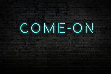 Neon işareti. Kelime tuğla duvara karşı. Gece görünümü