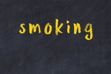 Üzerinde sigara içilen siyah karatahta.