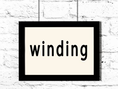 Beyaz tuğla duvarda asılı siyah çerçeve ve yazı sarmalı.