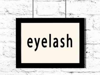 Beyaz tuğla duvarda asılı siyah çerçeve ve yazıt kirpiği