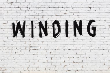 Beyaz tuğla duvara yazı yazılmış.