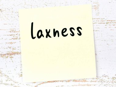 Tahta duvarda el yazısıyla yazılmış gevşeklikle sarı yapışkan bir not.