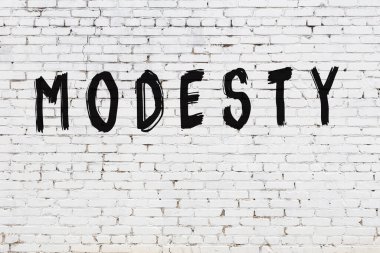 Üzerinde siyah boya yazılı beyaz duvar. Alçakgönüllülük.