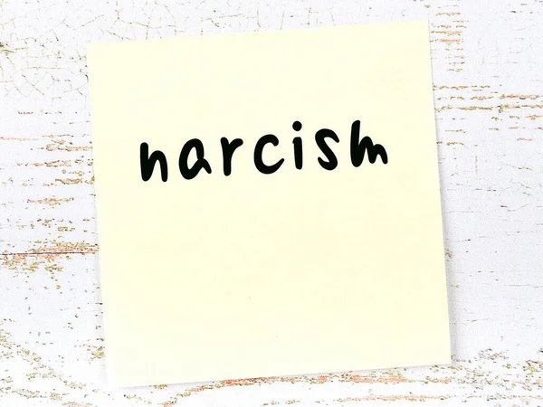 Желтый лист бумаги со словом нарцизм. Концепция напоминания — стоковое фото