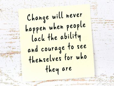 Ahşap duvardaki sarı yapışkan notta bilgece bir alıntı var.