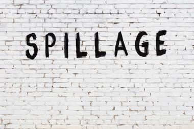 Üzerinde yazı olan beyaz tuğla duvar. Siyah boyayla yazılmış.