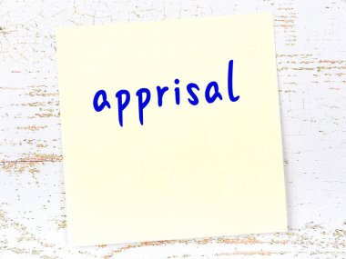 Tahta duvarda el yazısıyla yazılmış sarı yapışkan bir not var.