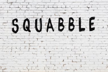 Yazılı beyaz tuğla duvar, el yazısı ve siyah boya.