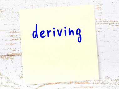 Tahta duvardaki sarı yapışkan notta elle yazılmış bir yazı var.