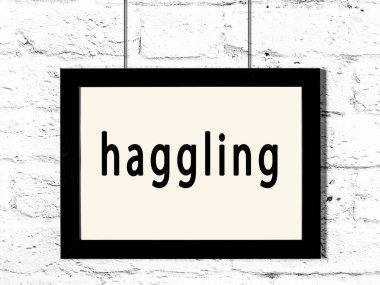 Üzerinde yazı olan siyah ahşap çerçeve beyaz tuğla duvarda asılı. 