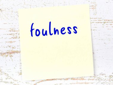 Tahta duvardaki sarı yapışkan notta el yazısı kirlilik var.