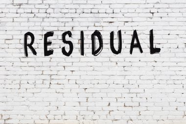 Beyaz tuğladan duvar, siyah boyayla yazılmış el yazısı.