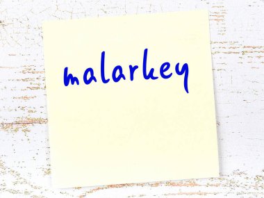 Tahta duvardaki sarı yapışkan notta el yazısıyla yazılmış saçmalıklar var.