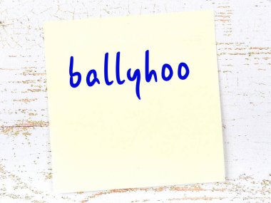 Tahta duvarda el yazısıyla yazılmış sarı yapışkan bir not.