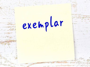 Örnek hakkında hatırlatma kavramı. Tahta duvarda üzerinde yazı olan sarı yapışkan kağıt.