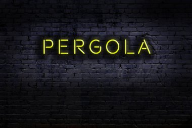 Tuğla duvara yazılı neon levhası. Gece görünümü