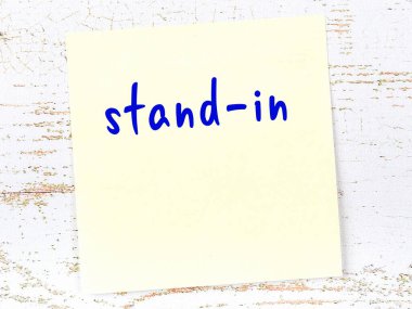 Tahta duvardaki sarı yapışkan notta el yazısıyla yazılmış dublör var.