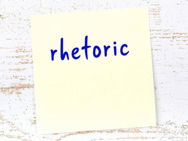 Retorik hakkında hatırlatma kavramı. Tahta duvarda üzerinde yazı olan sarı yapışkan kağıt.