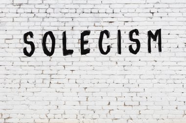 Üzerinde siyah boya bulunan beyaz tuğlalı duvar.