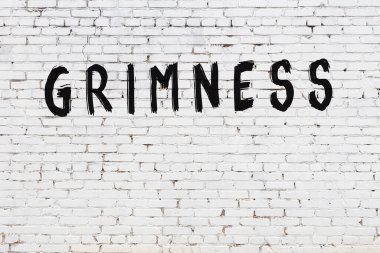 Beyaz tuğla duvara siyah boya ile yazılmış yazıtlar..