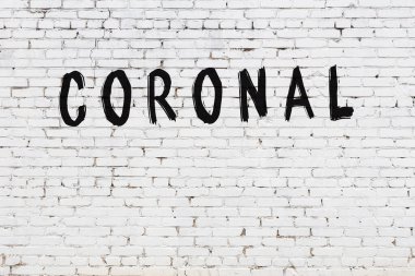 Siyah boyayla yazılmış beyaz tuğlalı bir duvar.