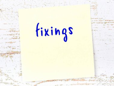 Tahta duvardaki sarı yapışkan notta el yazısı düzeltmeler var.