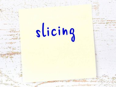 Tahta duvarda el yazısıyla dilimlenmiş sarı yapışkan bir not.