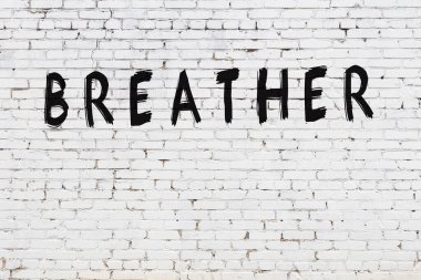 Üzerinde yazı olan beyaz tuğla duvar. Siyah boyayla yazılmış el yazısıyla nefes alan.