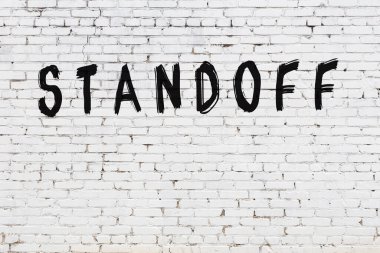 Yazılı beyaz tuğla duvar. Siyah boyayla yazılmış.