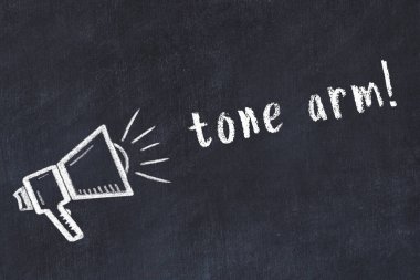 Hoparlörün tebeşir çizimi ve siyah masanın üzerine el yazısıyla yazılmış ses tonu kolu